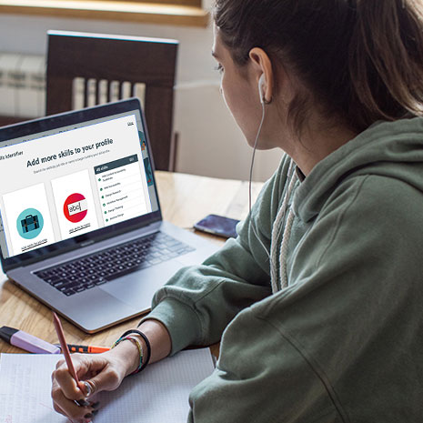 Woman listening to music while working on career profile