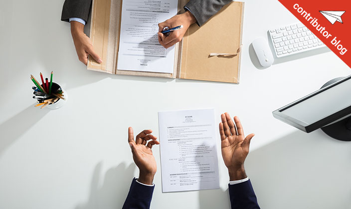 Bird's eye view of two people negotiating a salary, showing paperwork and hands only.