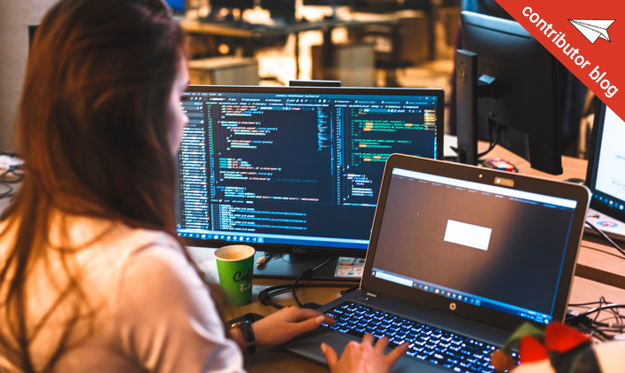 Female professional working in front of computer screens to represent business technology trends