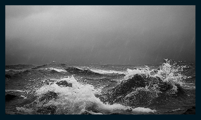 An image of waves crashing in black and white