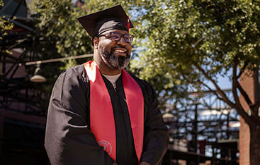 A happy graduate poses outside the commencement venue