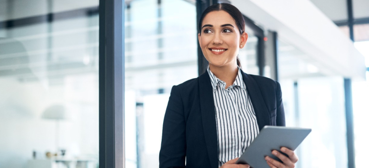 An adult student smiling with a tablet in their hands