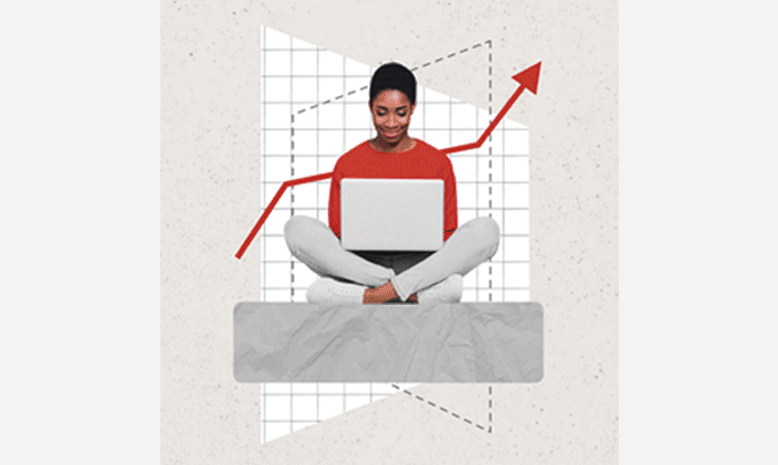 Woman wearing a red sweater and sitting cross-legged with an open laptop in her lap. 