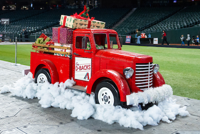 Chase Field is decorated with a red truck, snow, and gifts for the 2026 Arizona Diamondbacks Winter Classic event.