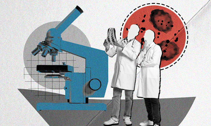 Two men in lab coats looking at a chart with a microscope in the background.