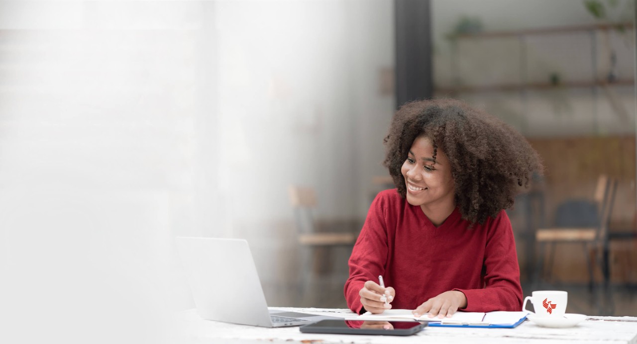A smiling student works on a research paper